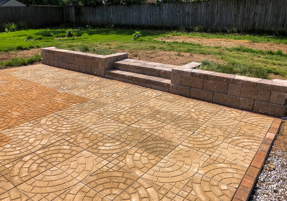 Circle pattern paver patio with a block retaining wall