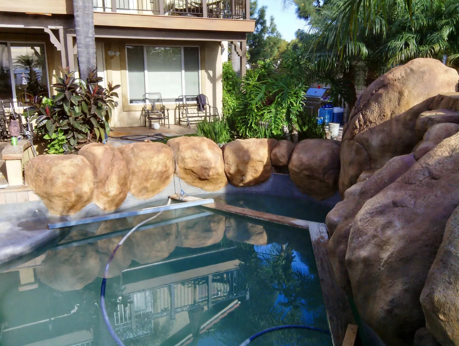 Faux boulders wrapping the corner of a backyard pool