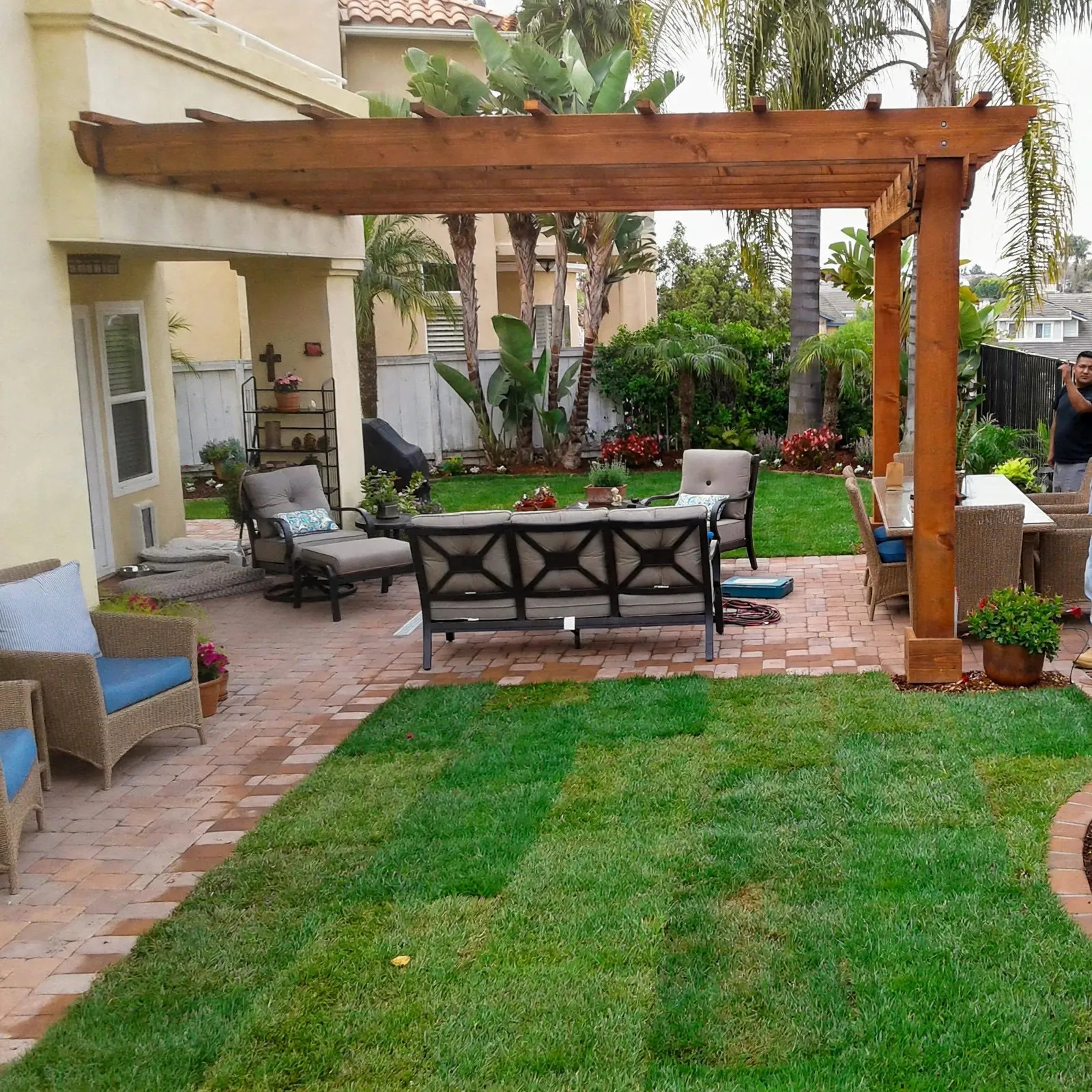 Wood pergola over a brick paver patio with outdoor seating