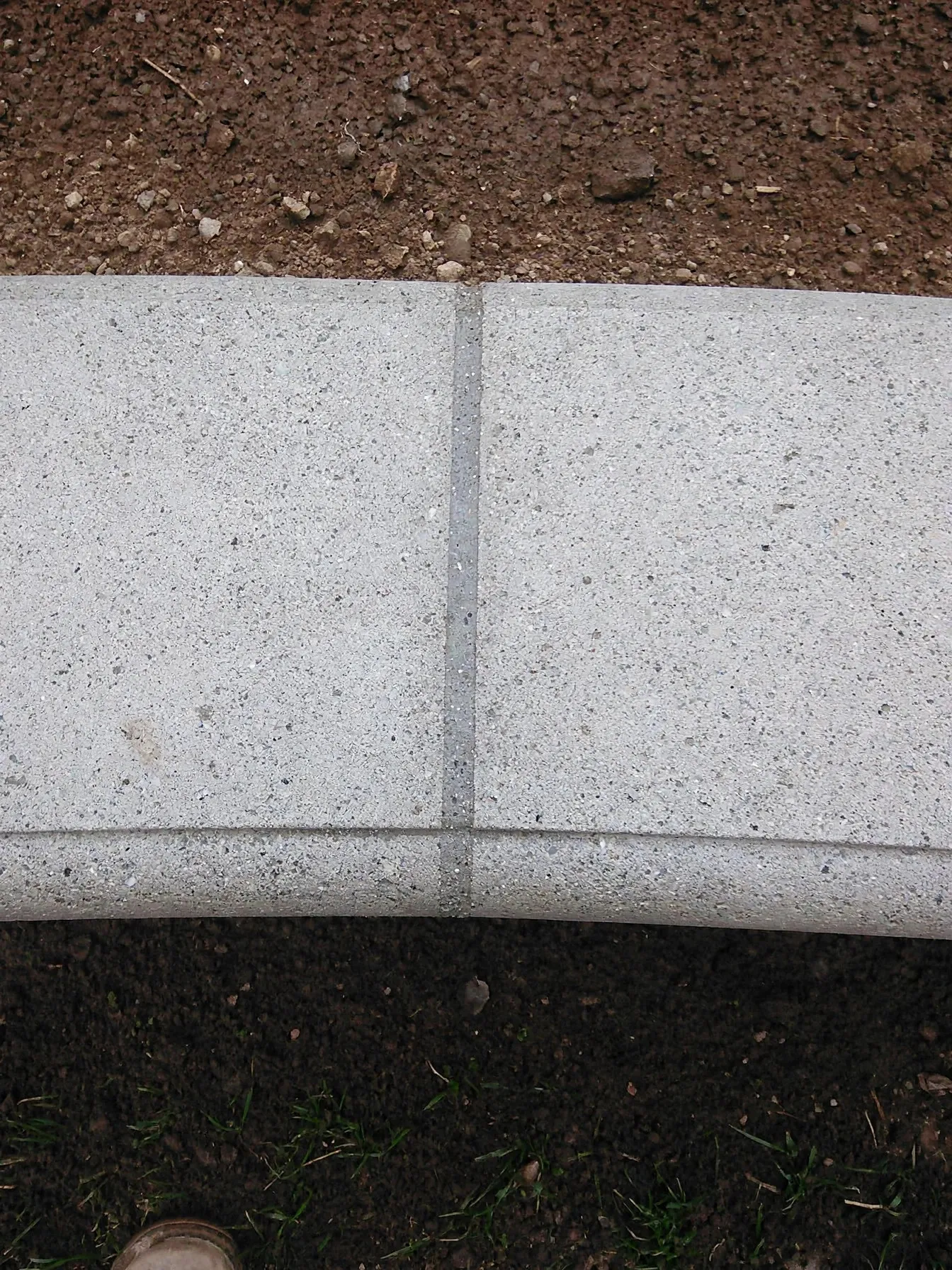 Concrete landscape curbing between a lawn and a mulch bed
