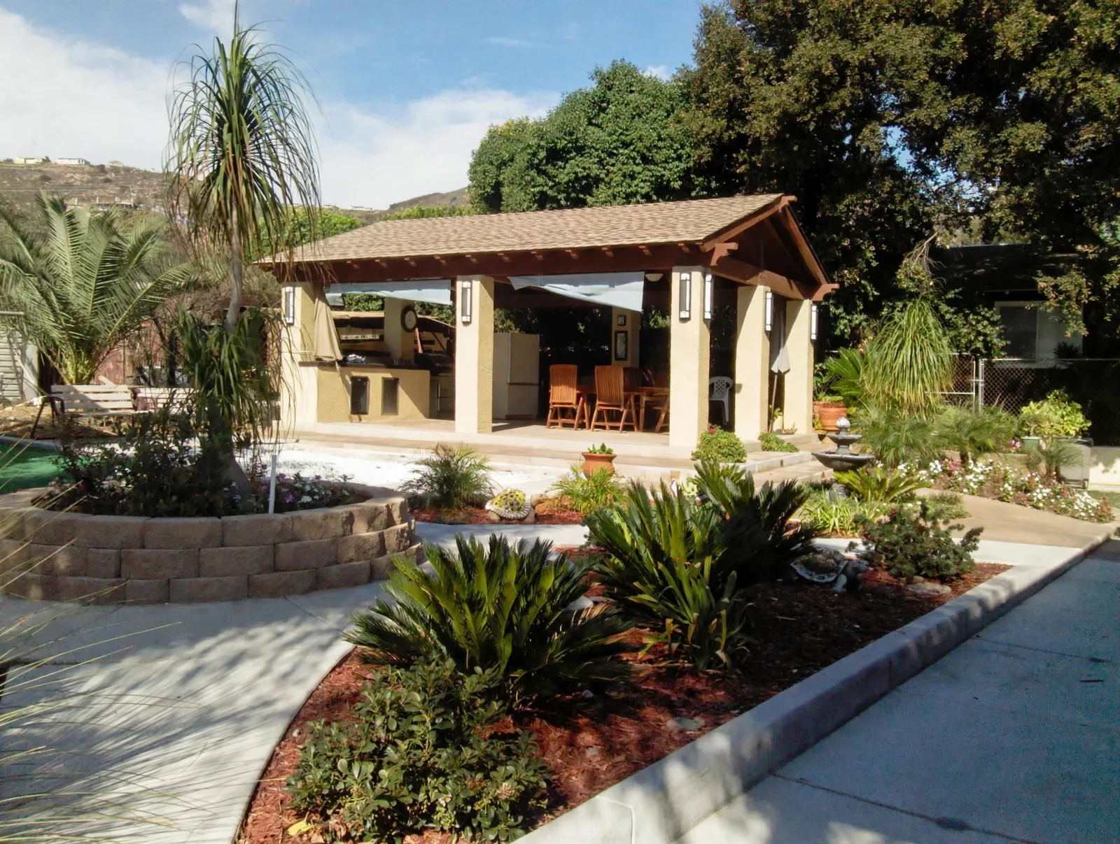 Patio cover with a concrete walkway and garden beds