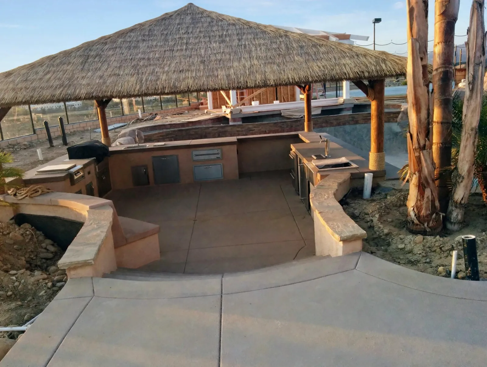 Curved outdoor kitchen counter under a palapa