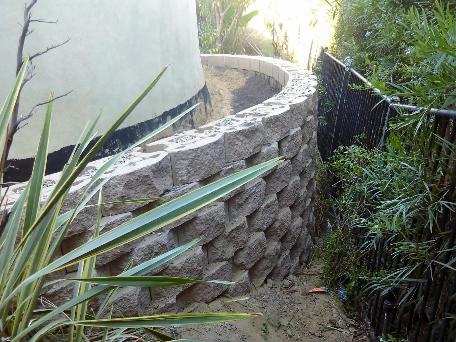 Curved retaining wall built from stone-faced block