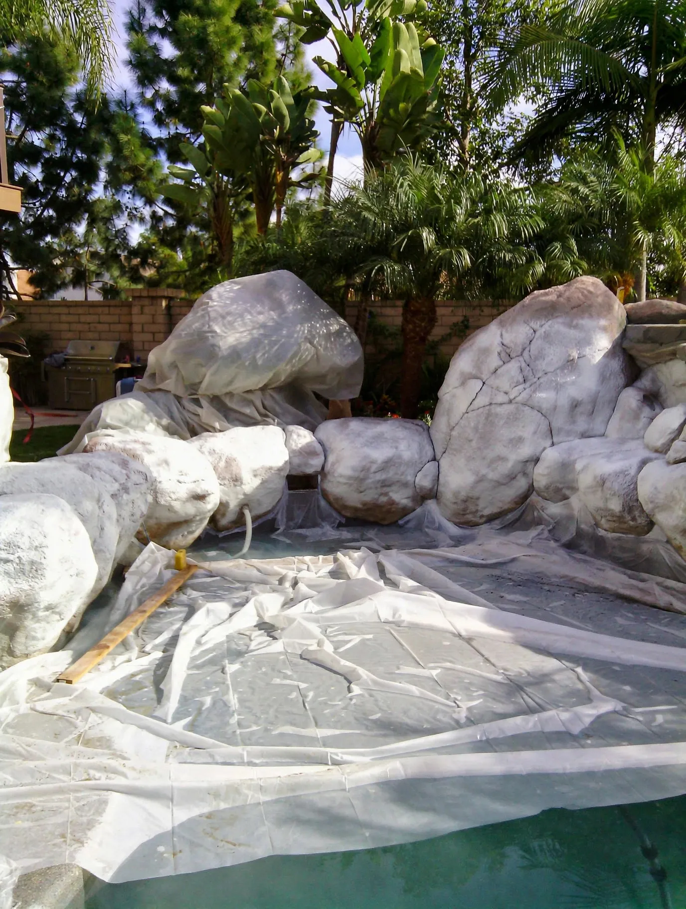 Decorative rock waterfall being built beside a pool
