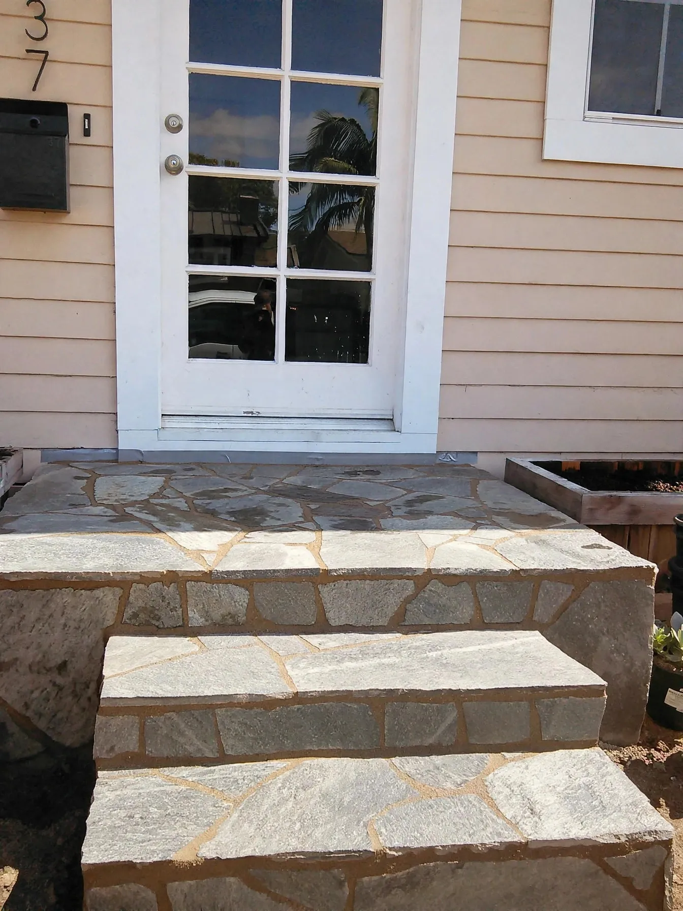 Front view of flagstone porch steps below a white door