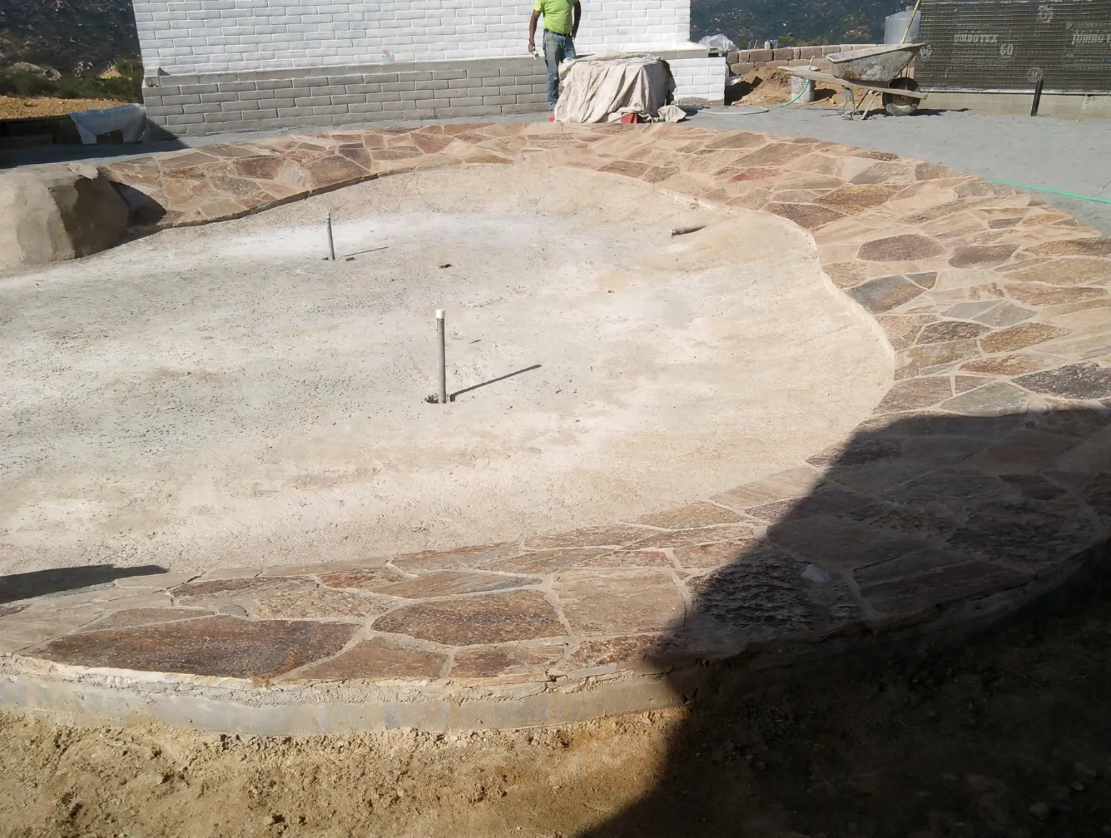Round patio with a random stone pattern beside a flagstone border