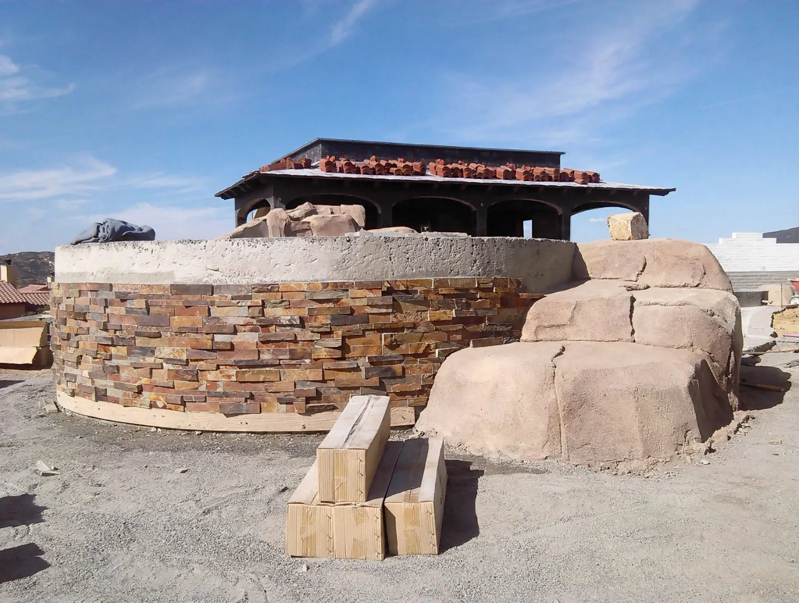 Stone veneer going onto a round spa wall during construction