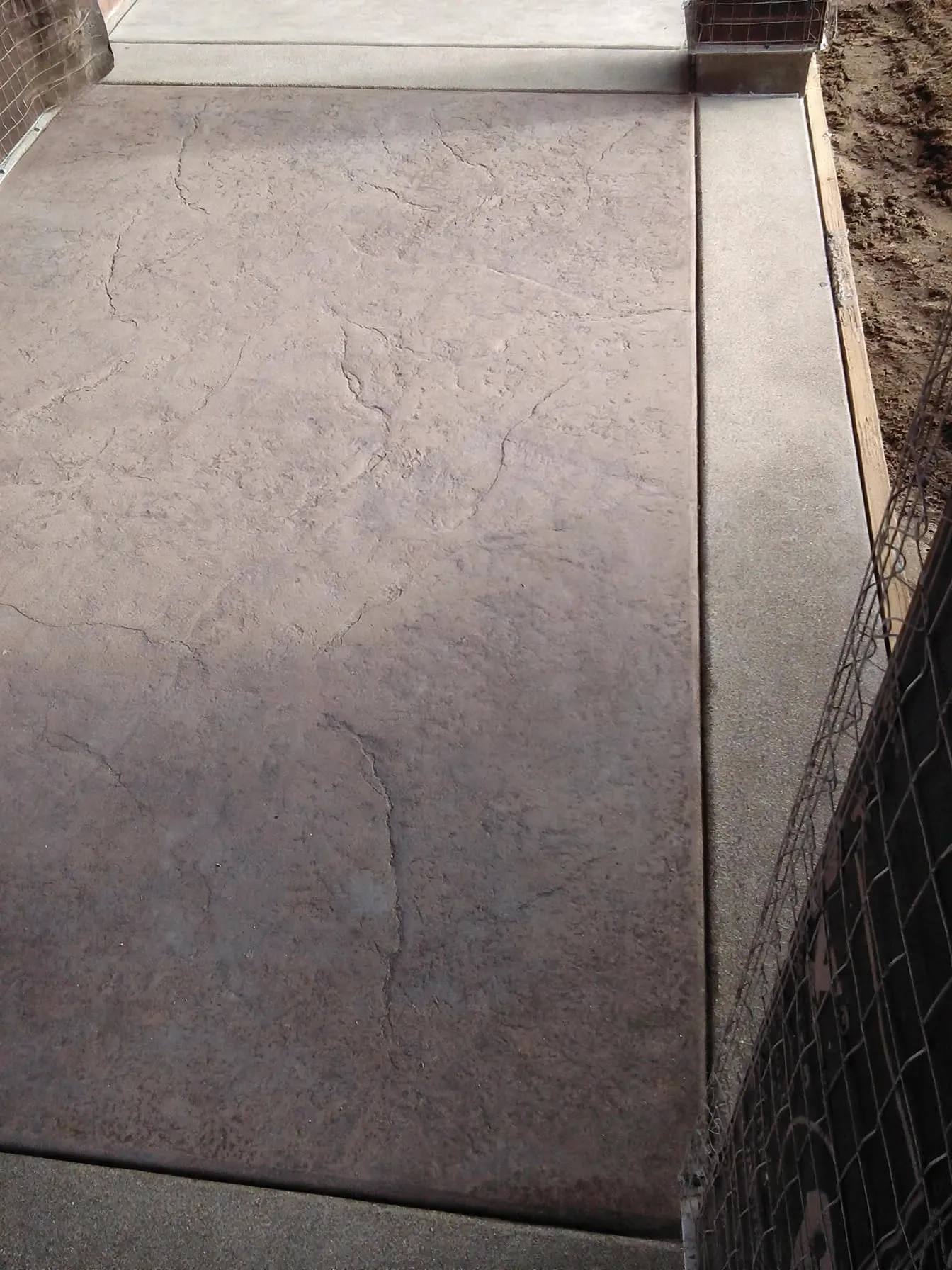 Stamped concrete entry walkway along the side of a home