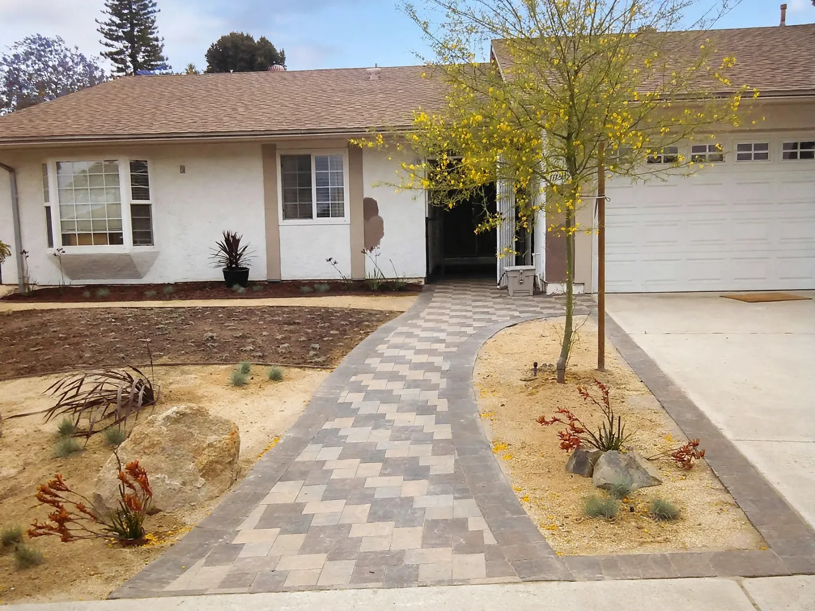 Two-tone patterned front walkway leading to a house