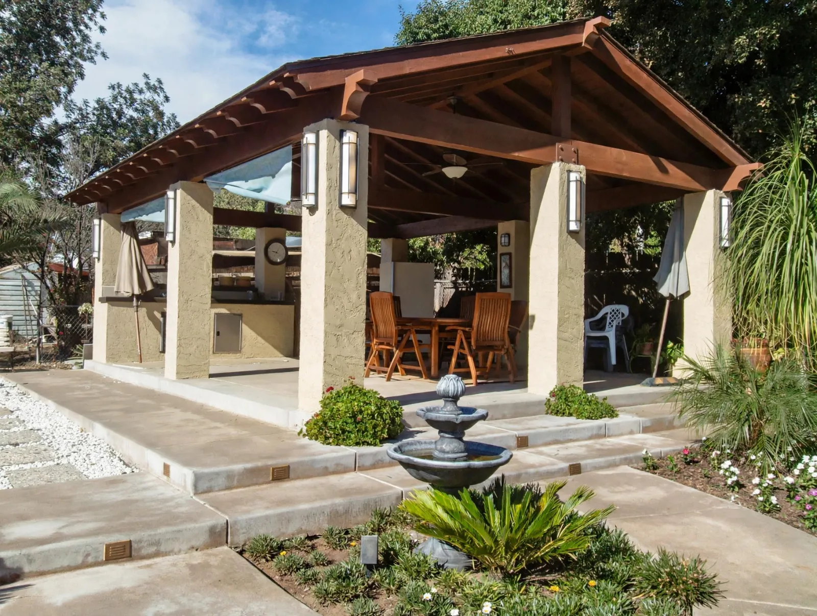 Wood patio cover with a fountain and paver steps in front