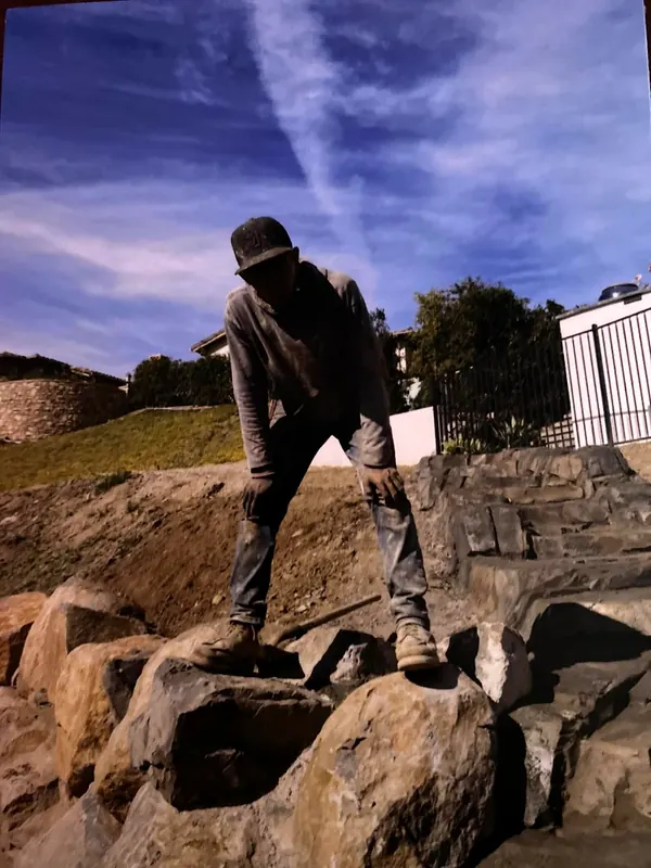 Builder standing on hand-built faux rock work