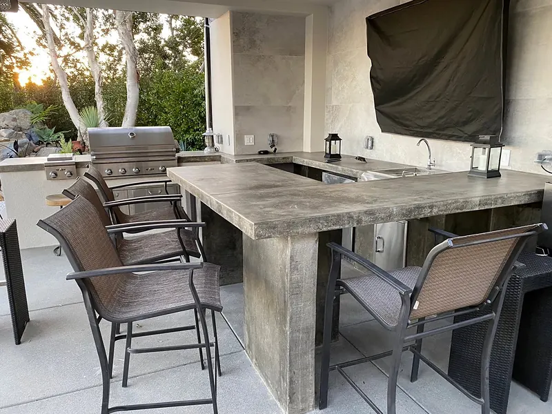 Cast concrete bar countertop with a built-in grill under a patio cover