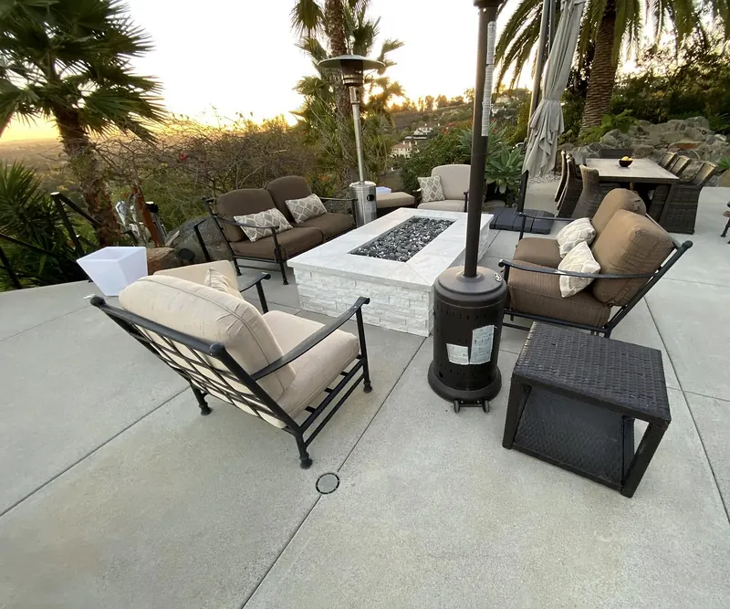 Stacked-stone fire pit on a concrete patio with lounge seating