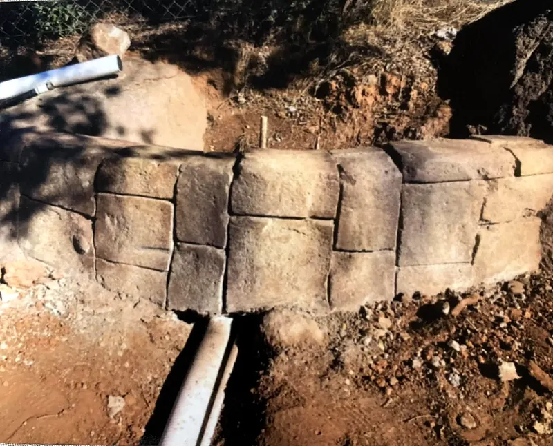 Carved faux stone curb wall under construction