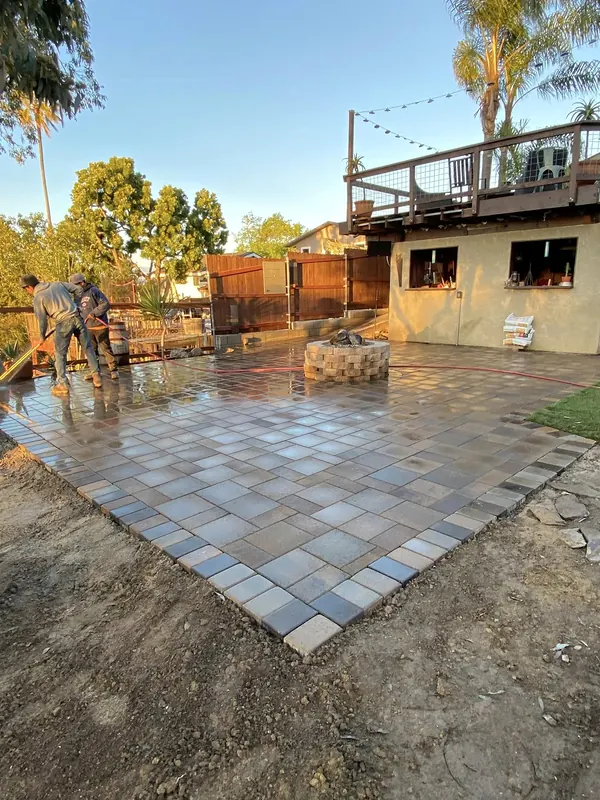 Paver patio being installed around a fire pit