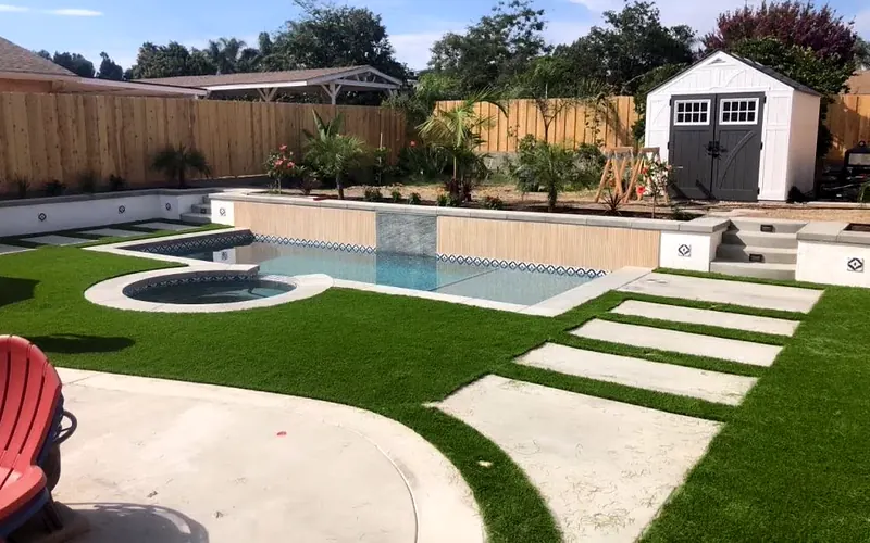 Pool and round spa with concrete coping, stepping pads and turf