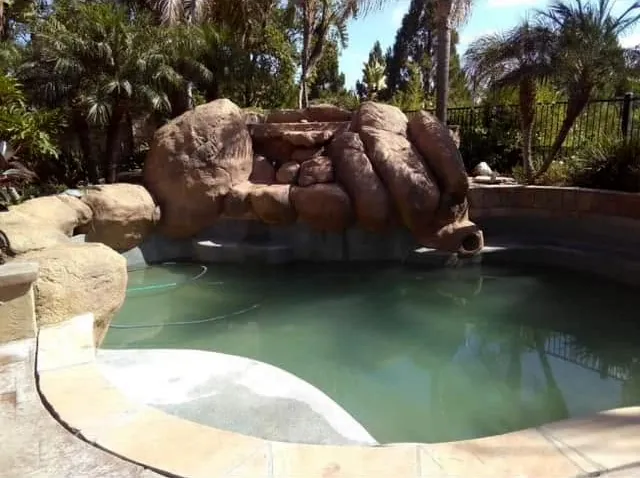 Faux boulder waterfall at a pool edge