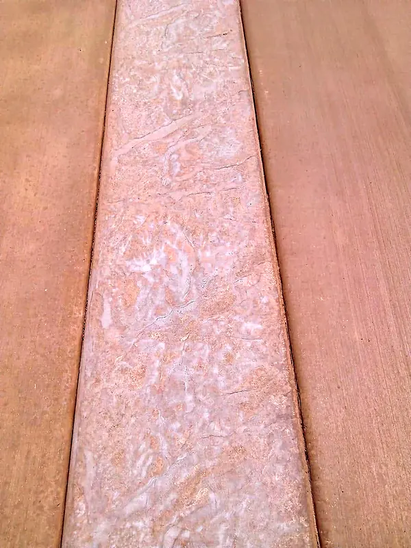 Close-up of a stamped border band on colored concrete