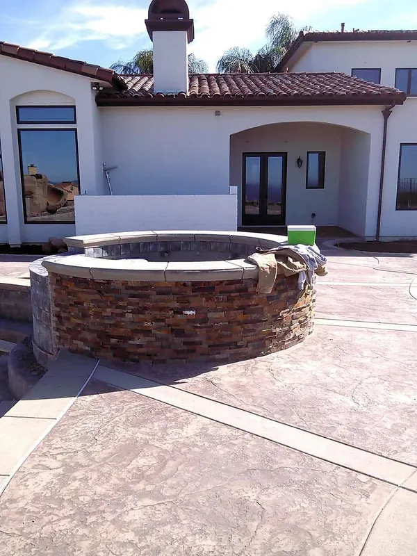 Stacked-stone raised spa on a stamped concrete patio