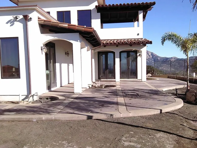 Stamped concrete patio with banded borders at an arched entry