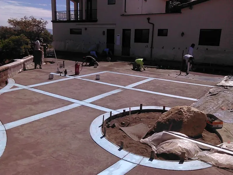Crew finishing a stamped concrete courtyard grid