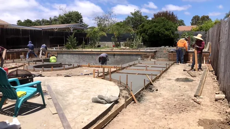 Forms set and concrete placed for stepping pads beside a pool