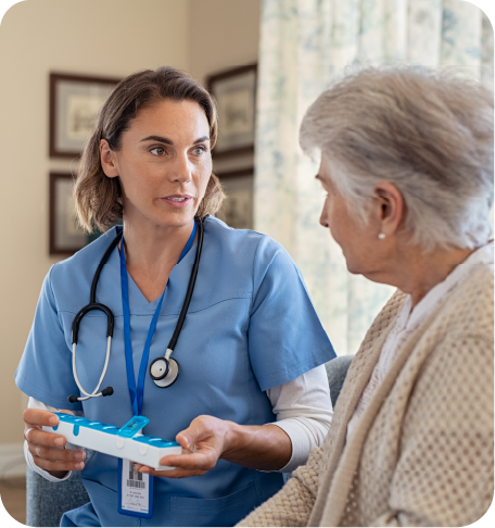 A brown haired white nurse talking to a Grey haired White elderly woman