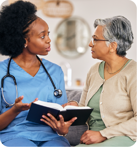 A black female nurse explaining something to a colored elderly woman