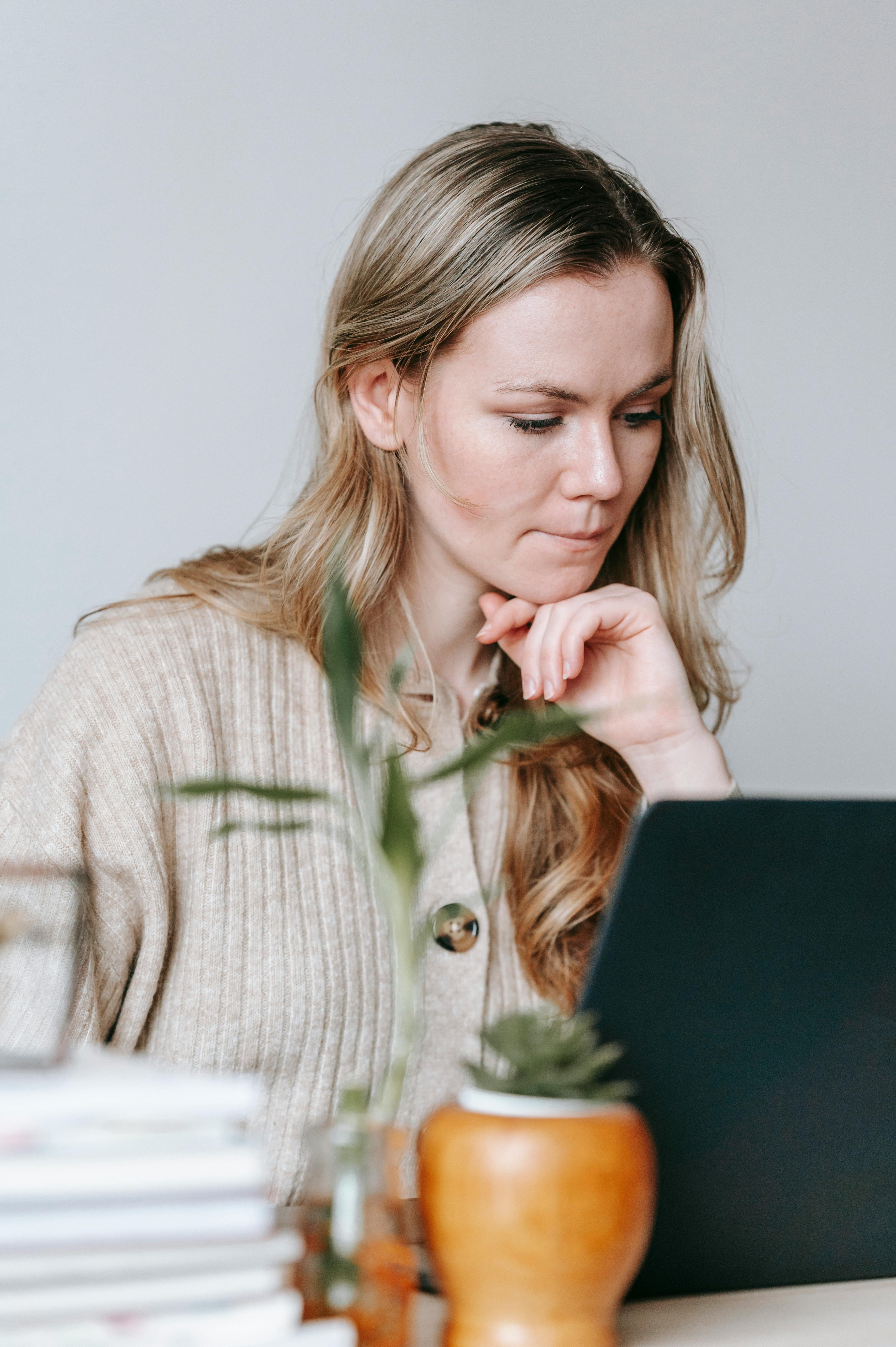 An established service provider working at her laptop, representing the reality of running a business that depends on you being present for every sale An established service provider working at her laptop, representing the reality of running a business that depends on you being present for every sale