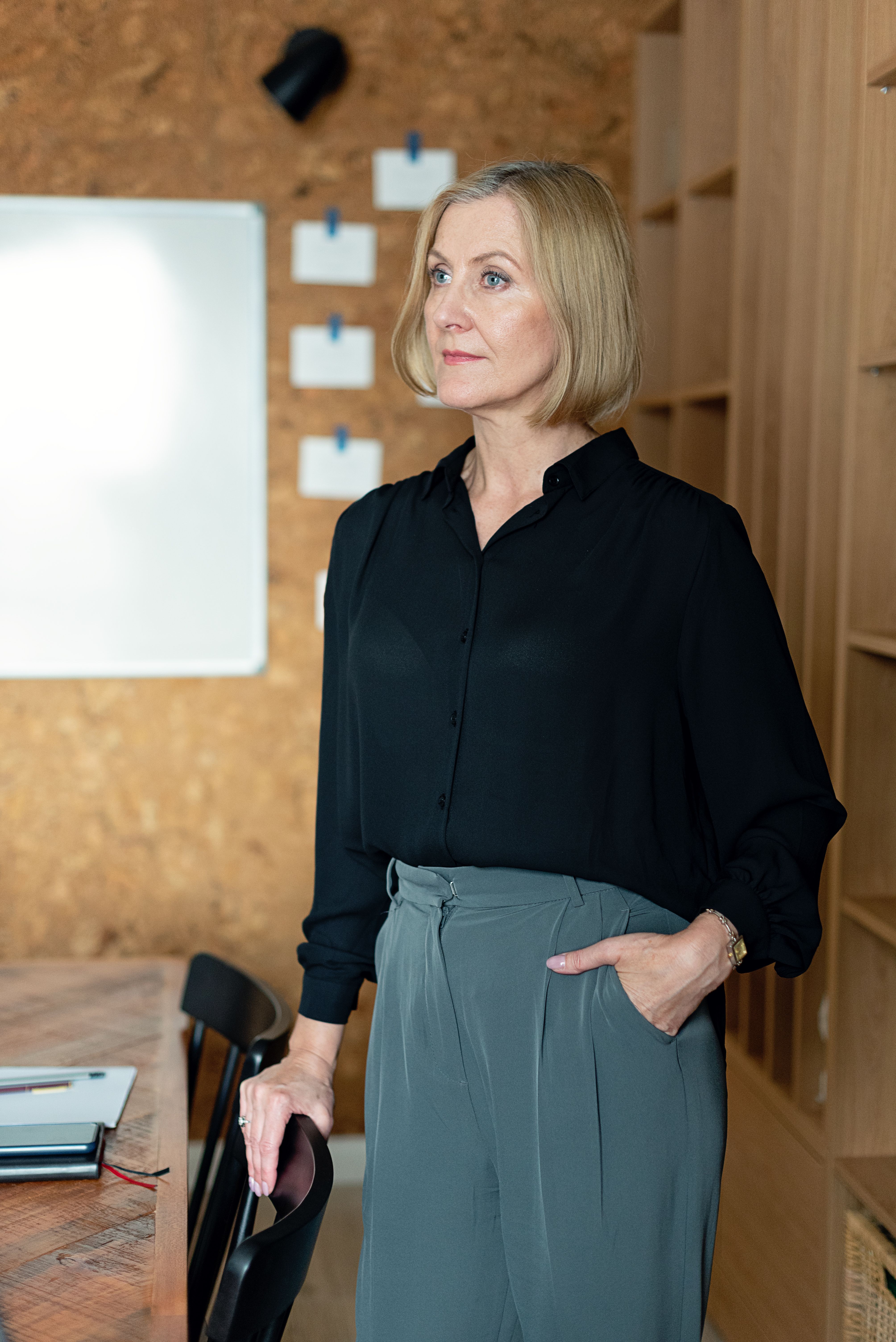 A business owner standing calmly in her workspace looking forward with quiet confidence and clarity. A business owner standing calmly in her workspace looking forward with quiet confidence and clarity.