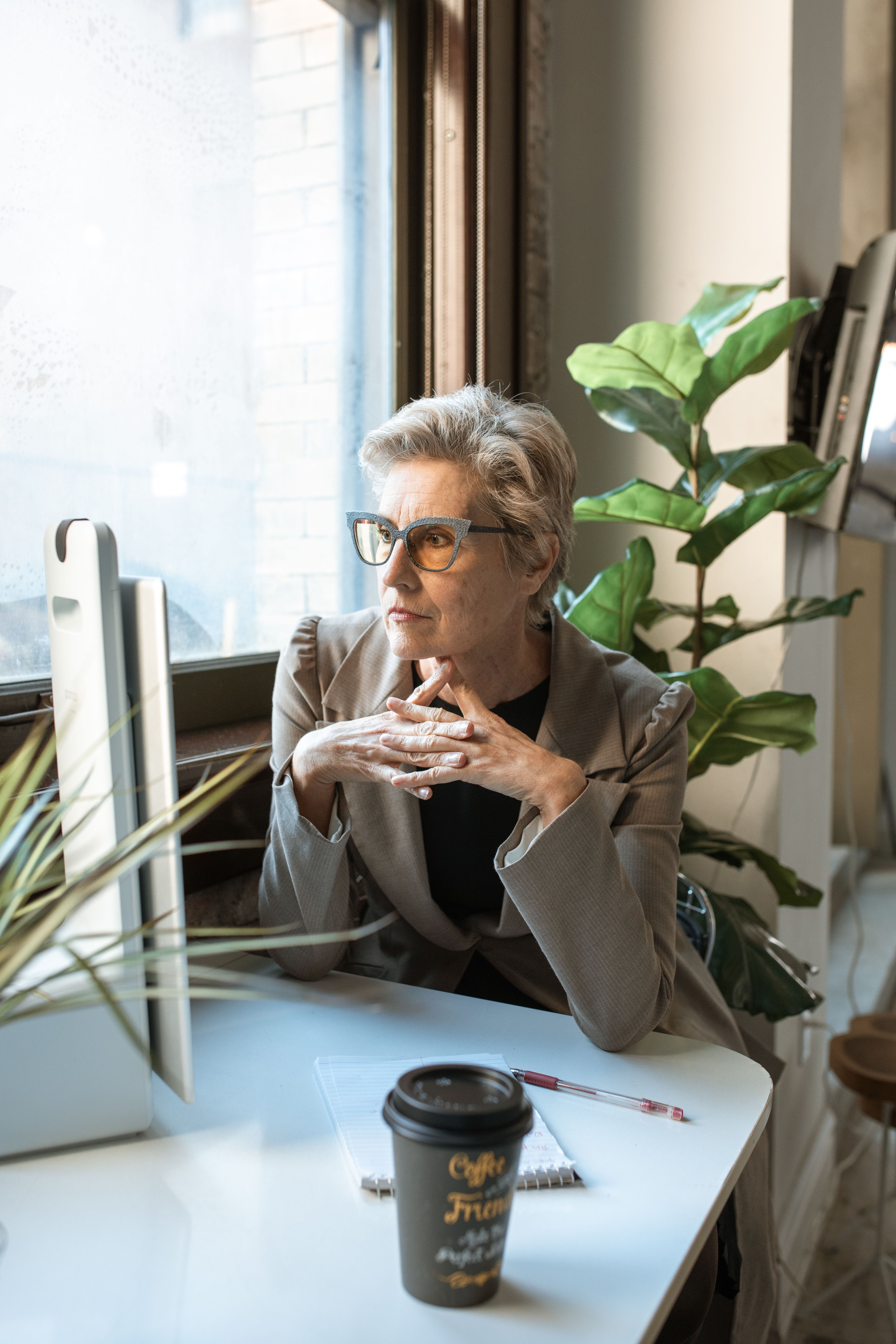 An established business owner sitting at her desk looking seriously at her screen considering what her business could be earning.