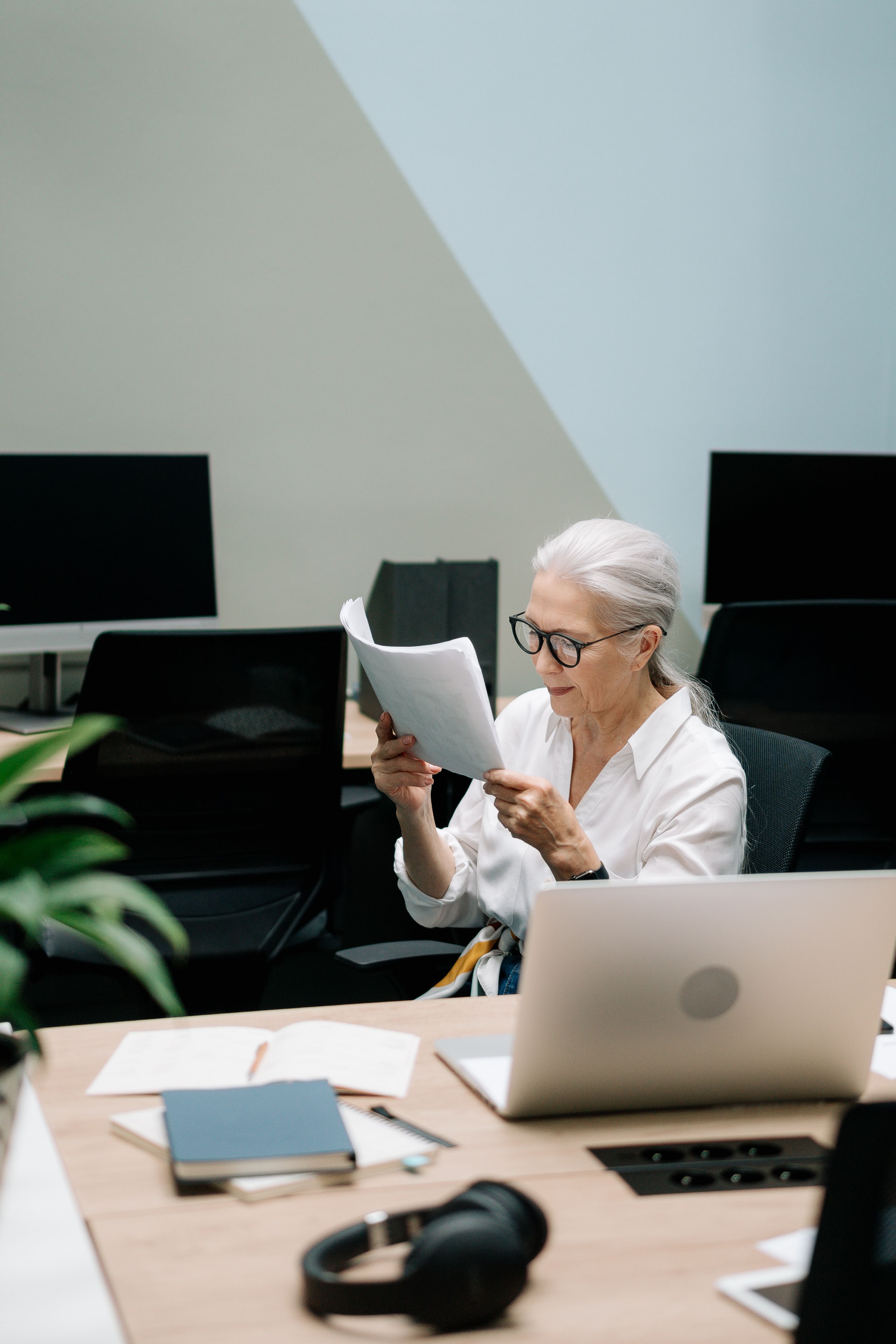 A professional woman reviewing documents carefully, representing the structured external perspective that a Brand Alignment Audit provides for established service providers.