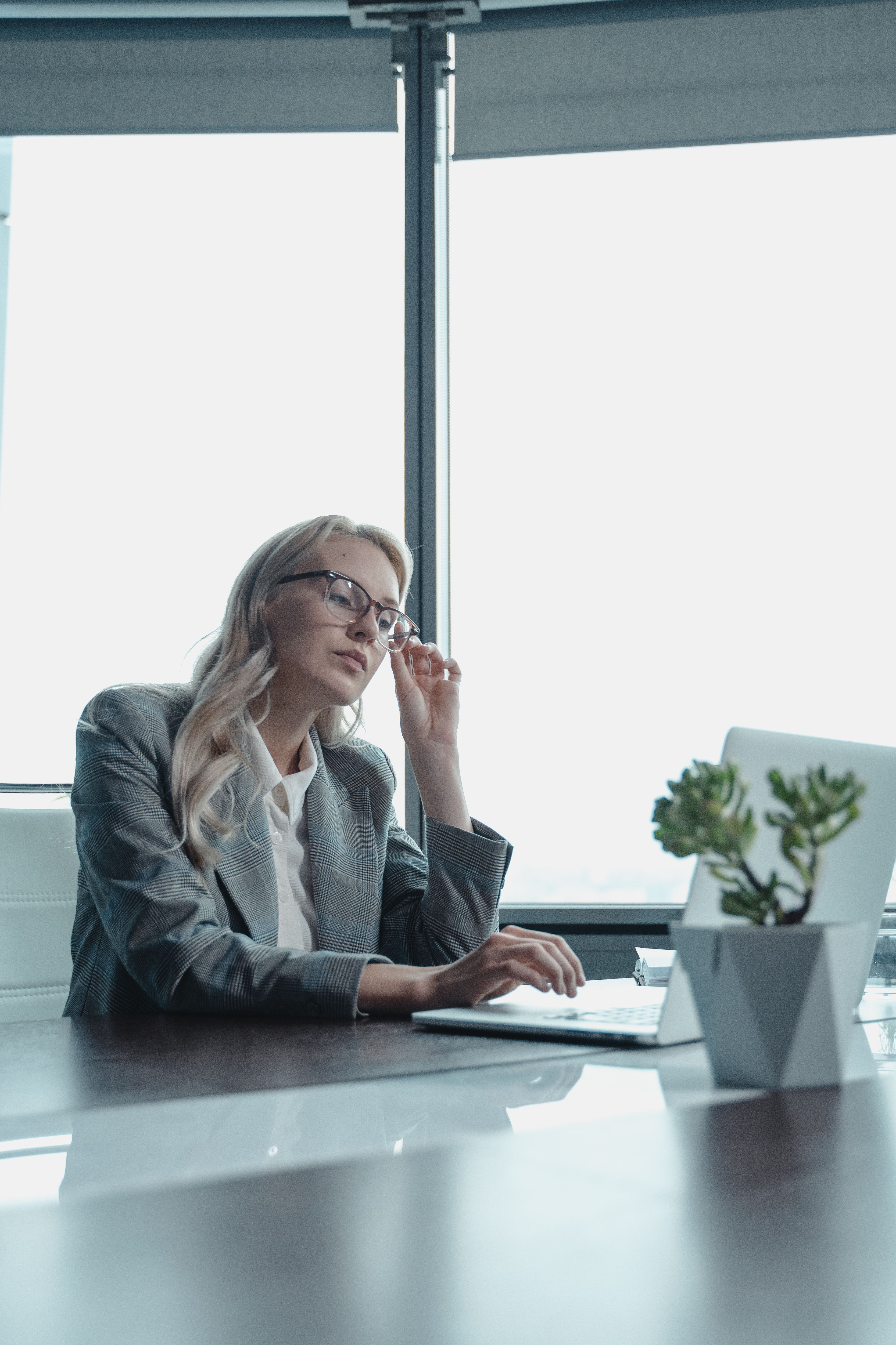 An established professional pausing to consider her next business decision, representing the moment of moving from uncertainty to a grounded, evidence-based choice.