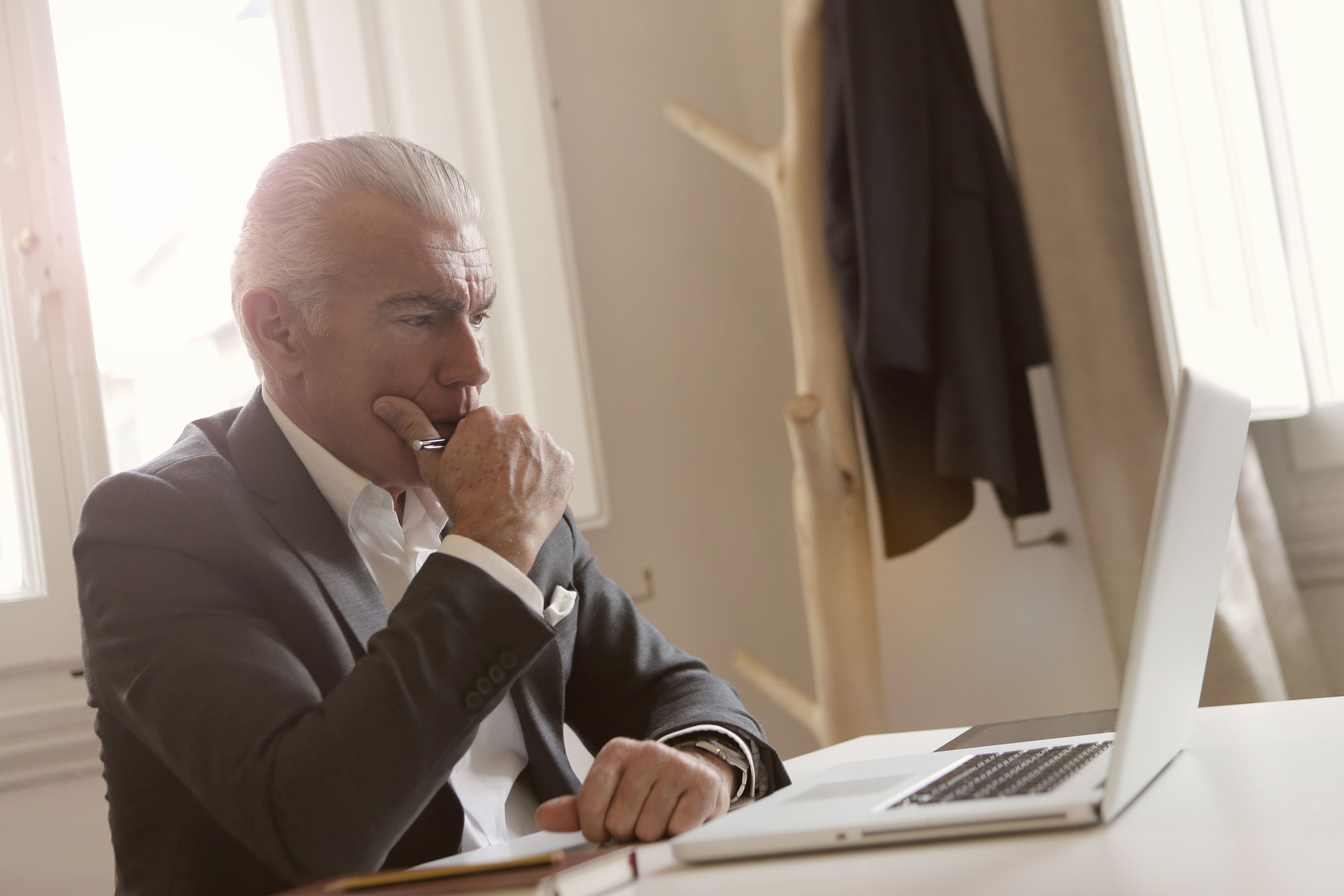 An established business owner at his desk reviewing his work, representing the experience of having built something real but carrying every brand standard in his head rather than in a document.