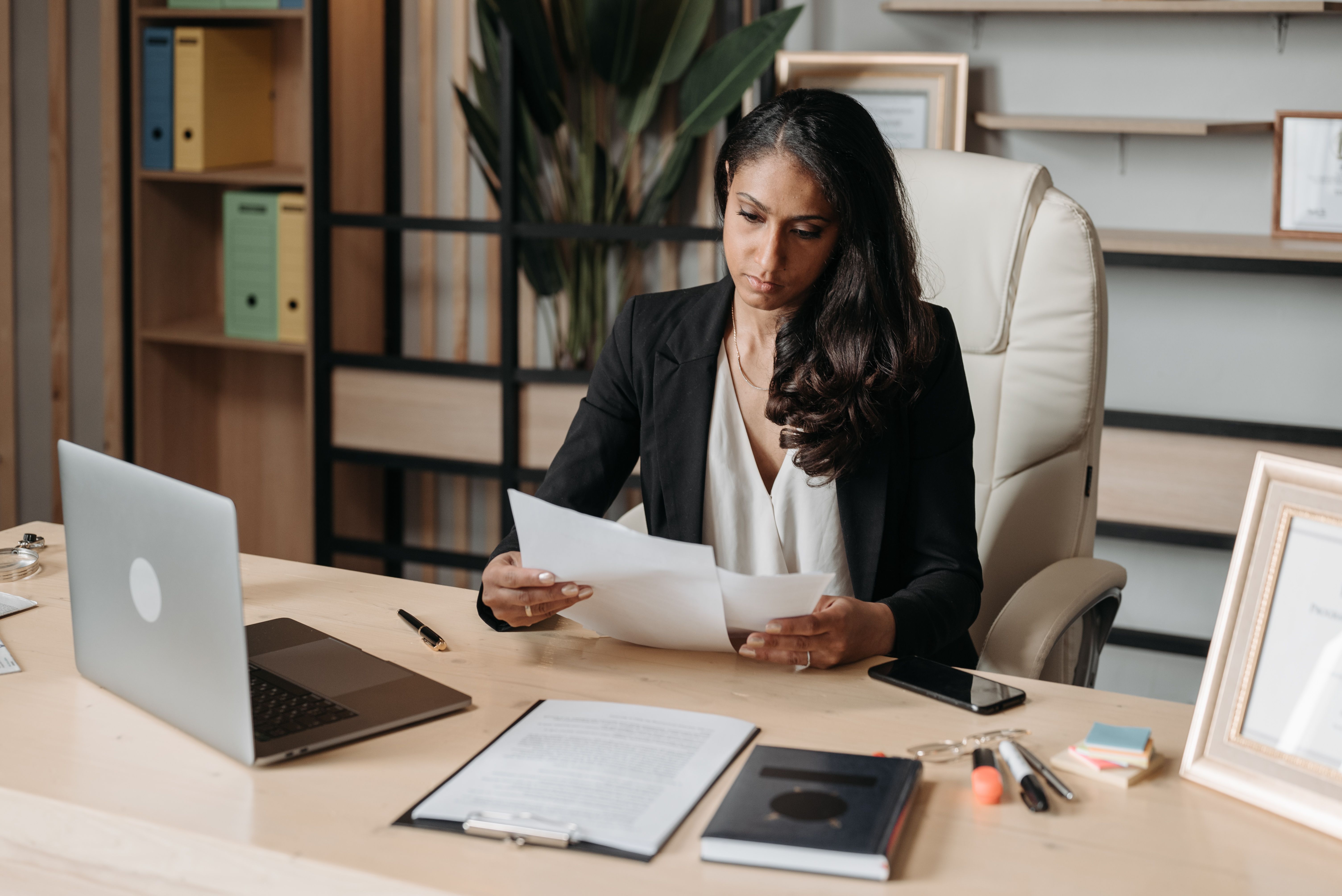 A professional reviewing documents with structured focus, representing the external brand assessment that finds the gap between what a business has built and what a cold audience actually experiences.