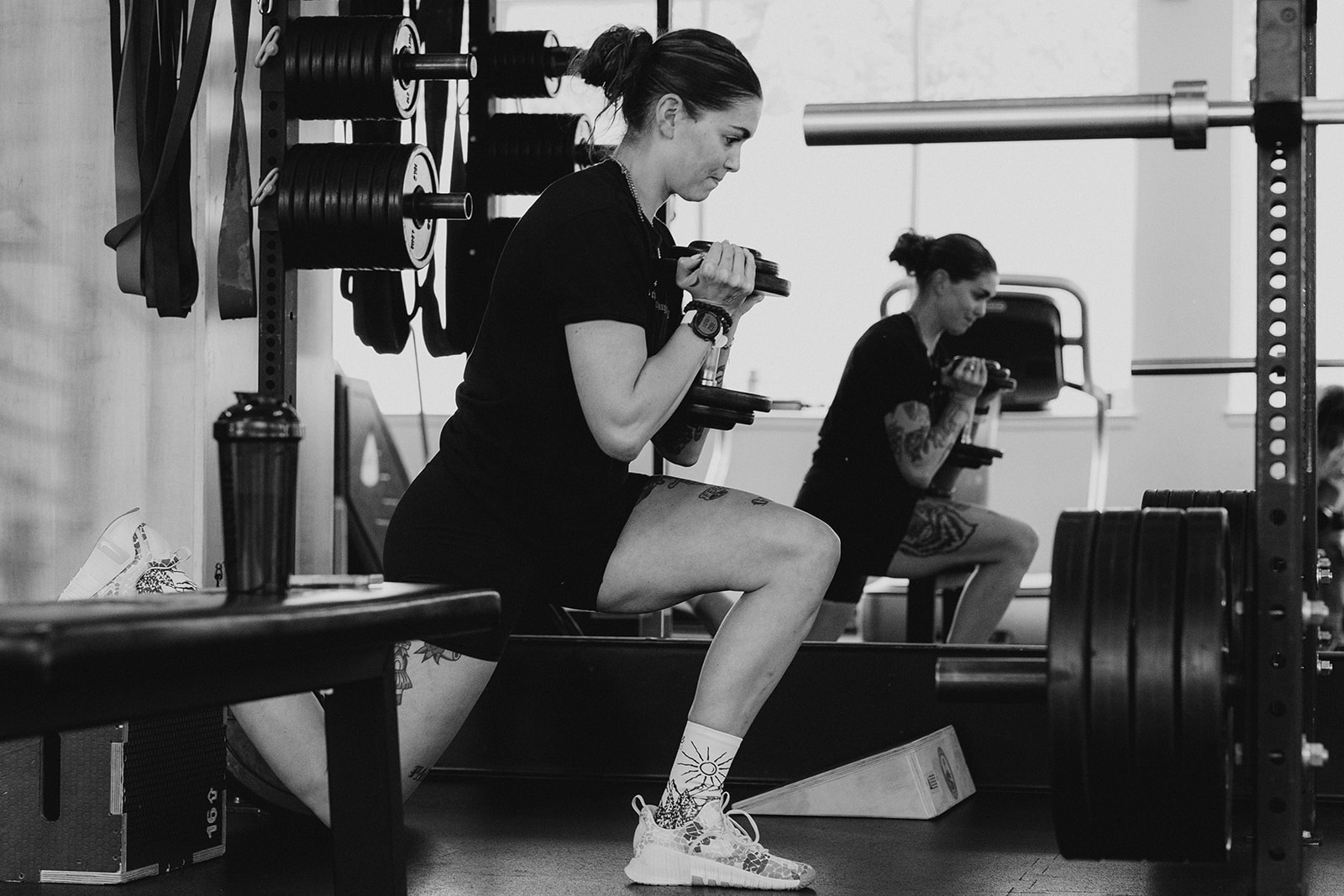 Member training with dumbbells at the rack