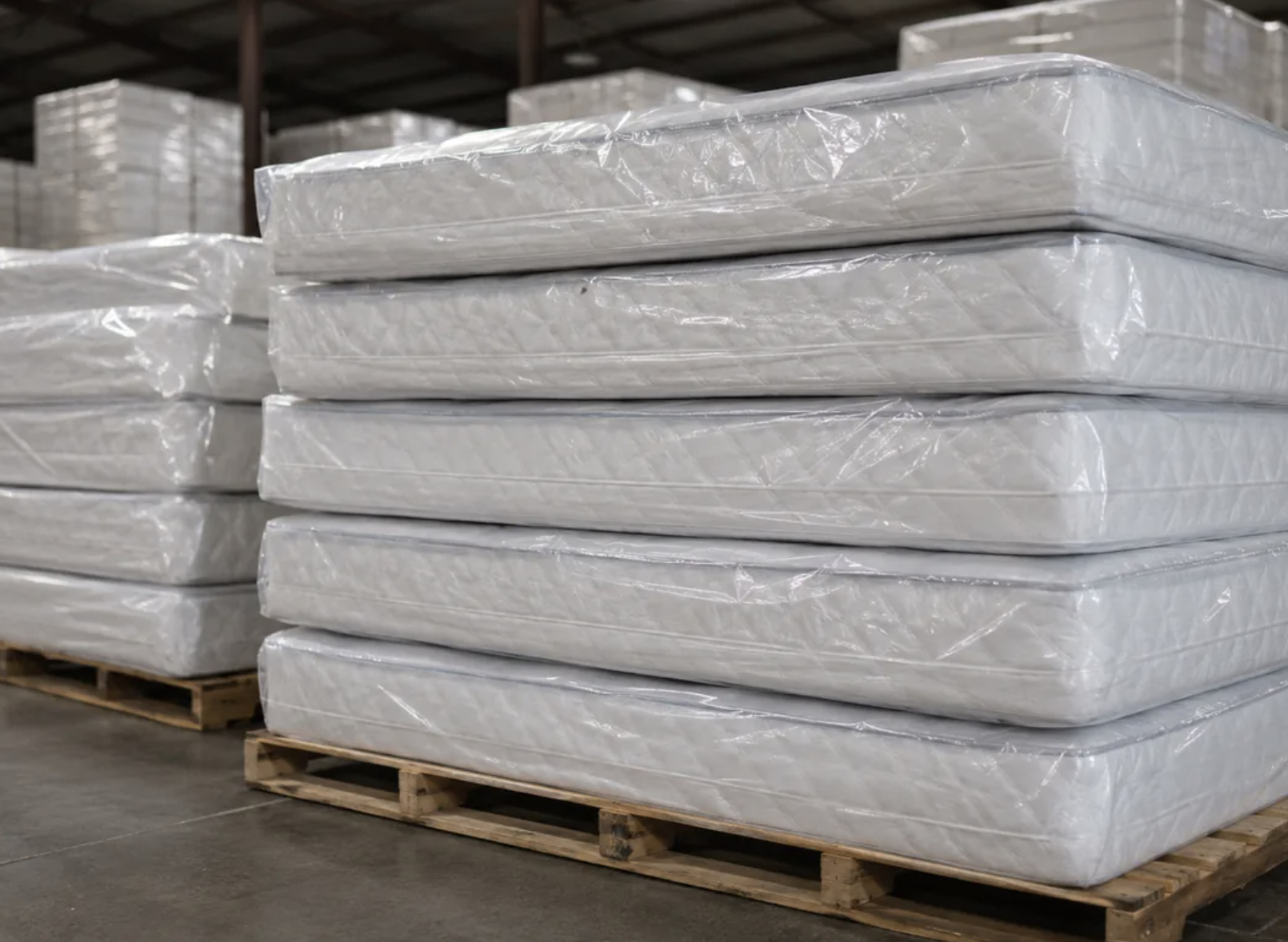 Warehouse worker moving mattress inventory