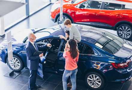 A salesperson working a buyer at the vehicle during an event