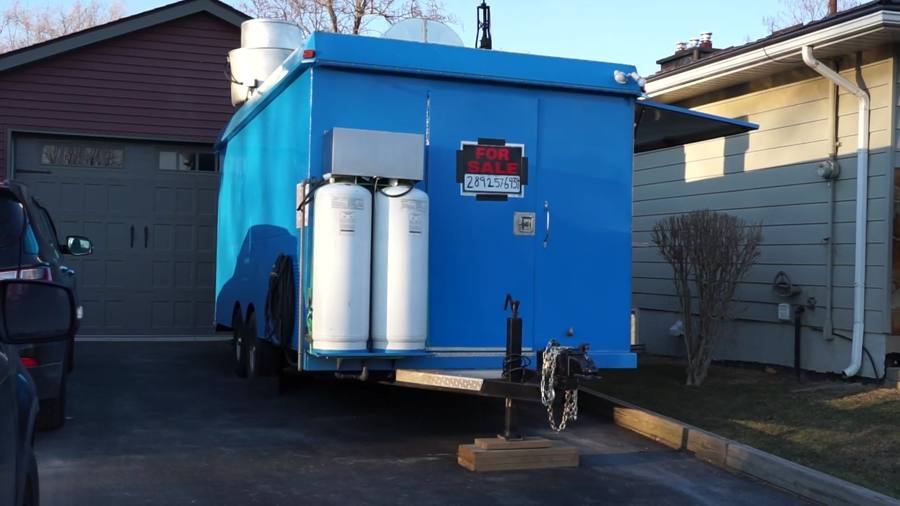 A blue concession trailer parked in a driveway