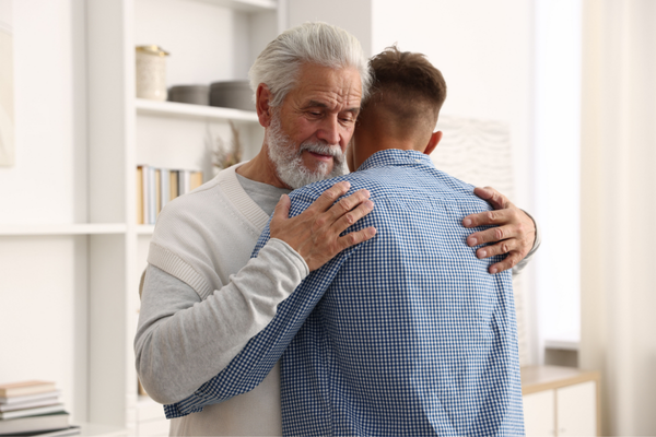 A senior man hugging his son post falling over on the floor