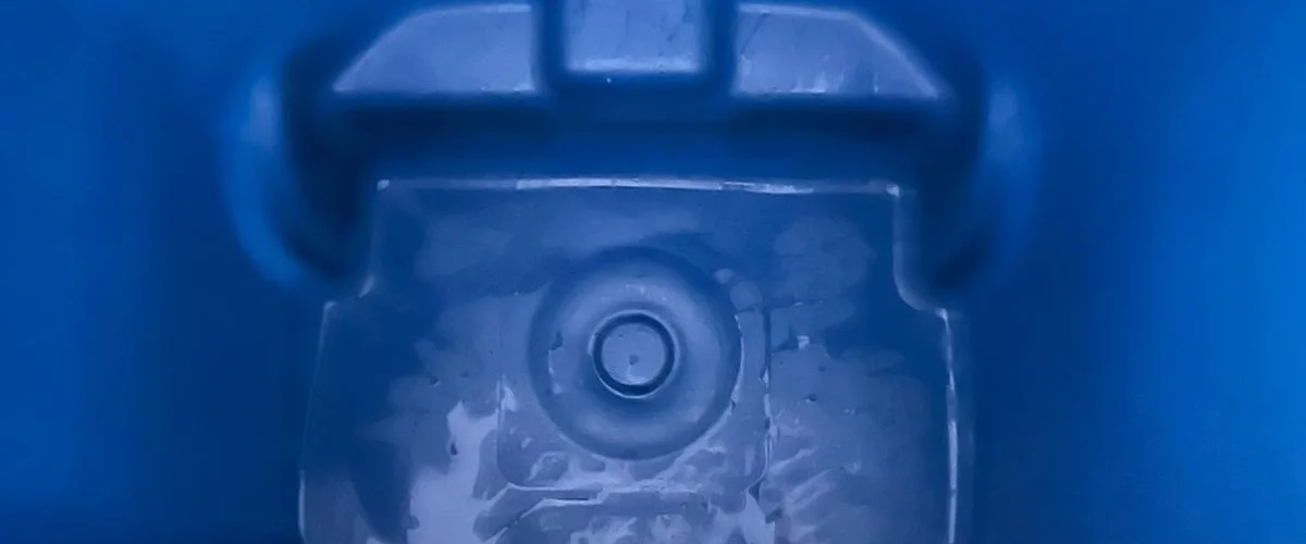 A close-up, abstract view of a blue plastic molded object with a circular indentation. A close-up, abstract view of a blue plastic molded object with a circular indentation.