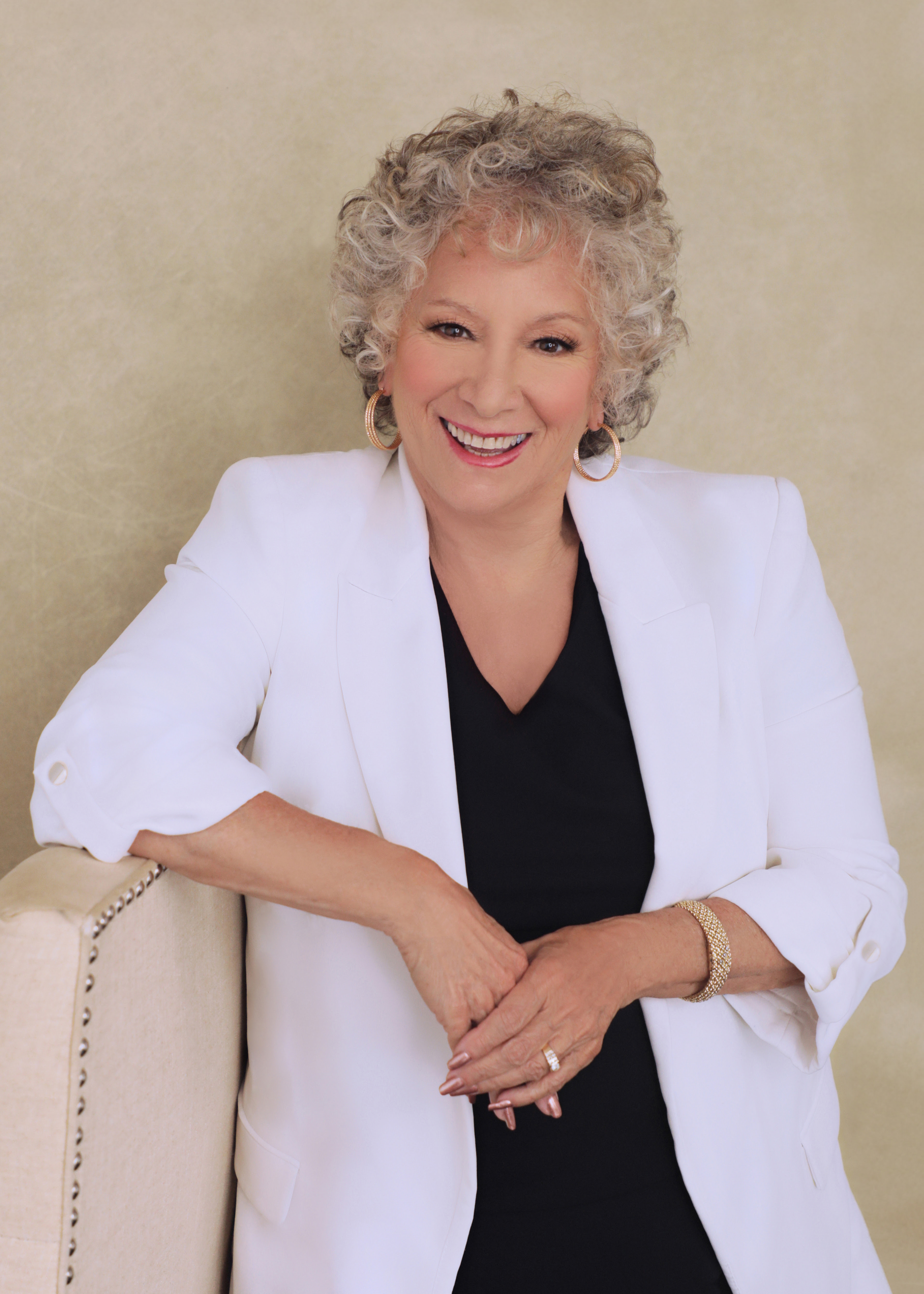 Gail Stevens, smiling, in a white blazer