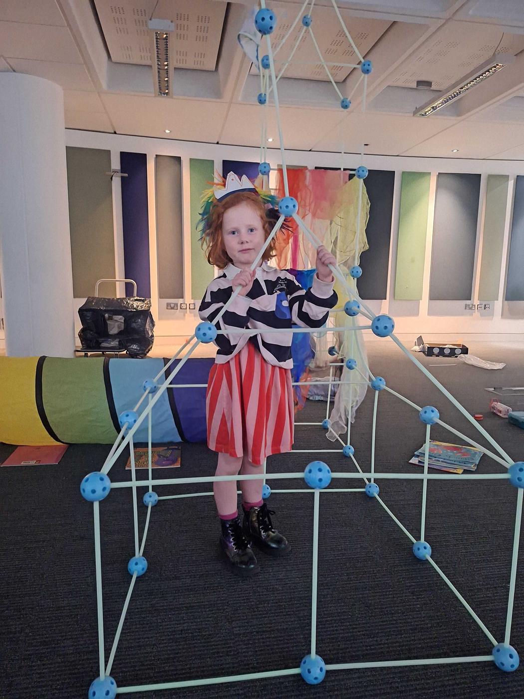 A child building a den in an office space