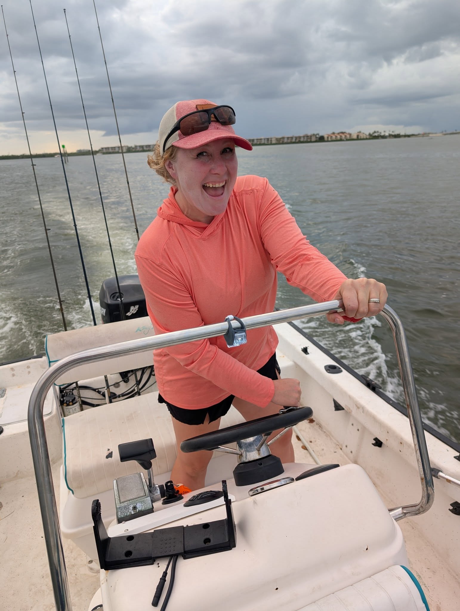 Lacie Preisler, founder of OutCast Company, at the helm of a boat