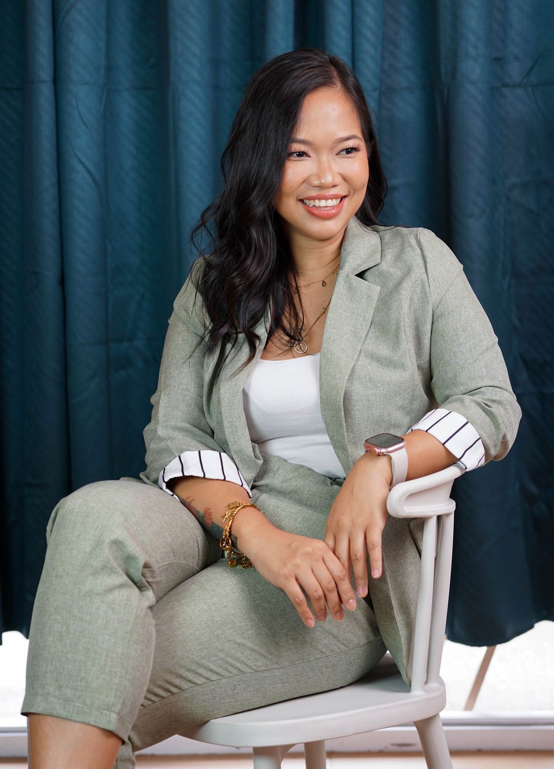 Annikka Aborro seated in a sage suit, smiling