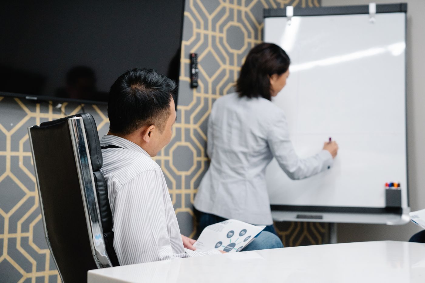 Two people planning strategy at a whiteboard