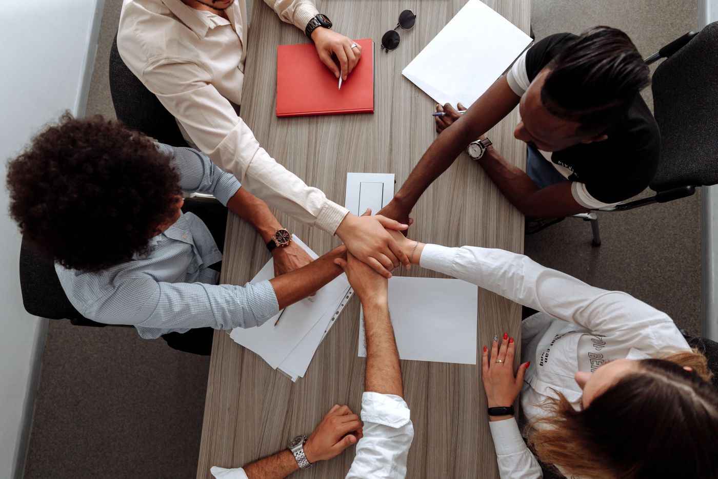 A team stacking hands over a table