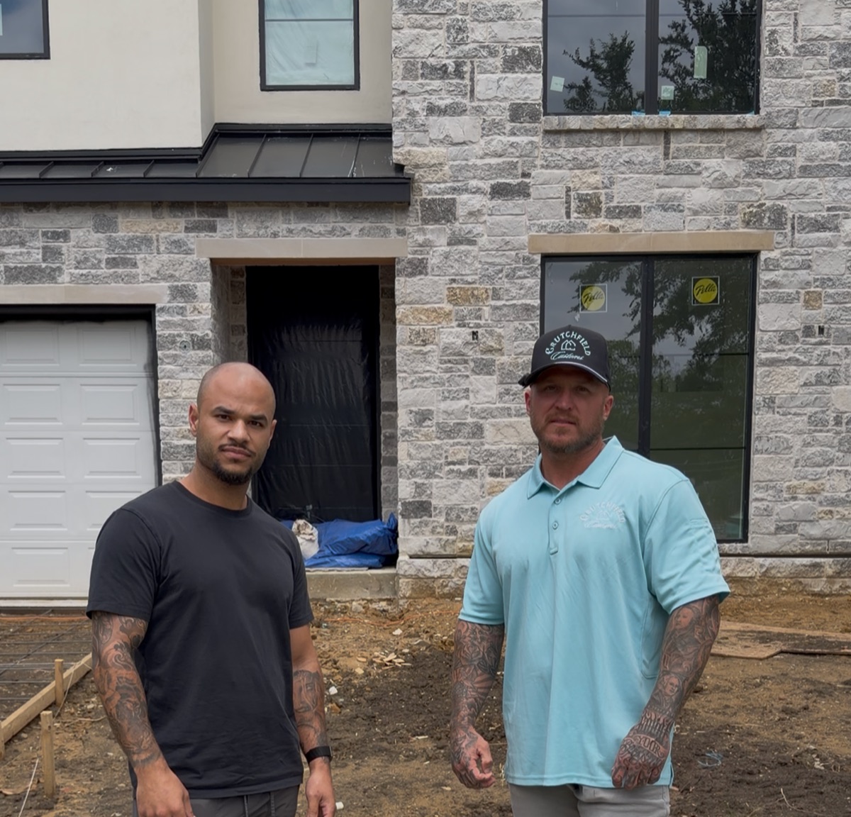 Eli in front of modern townhome construction