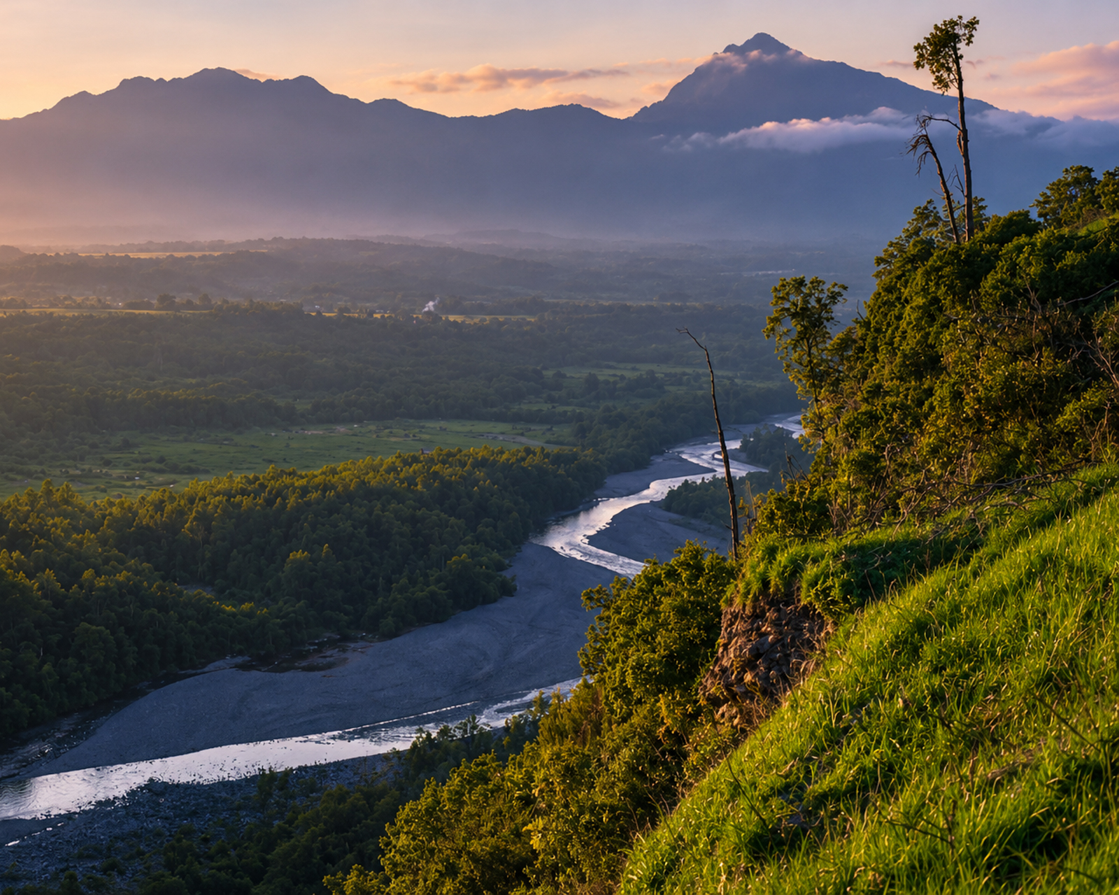 A river bending through a forested valley, seen from a high rim at dawn.