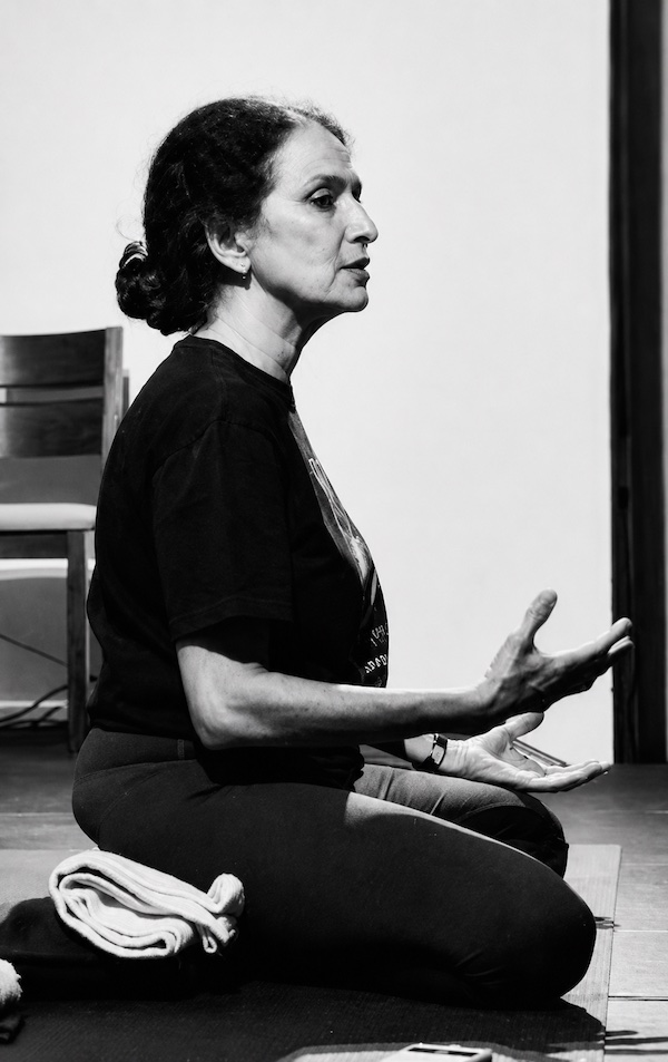 Firooza Razvi adjusting a student's alignment during practice